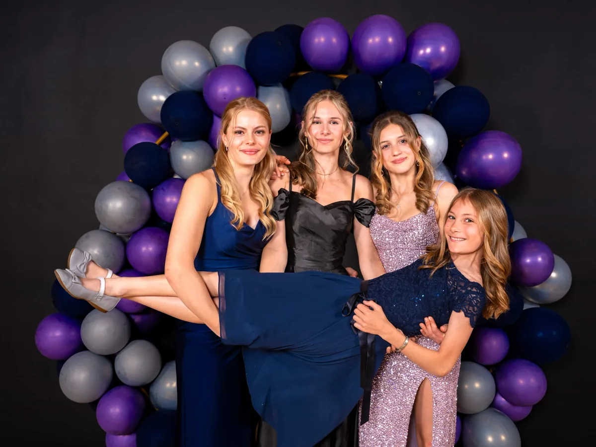 Gruppe vor der Fotowand auf einem Ball, Abendgarderobe.