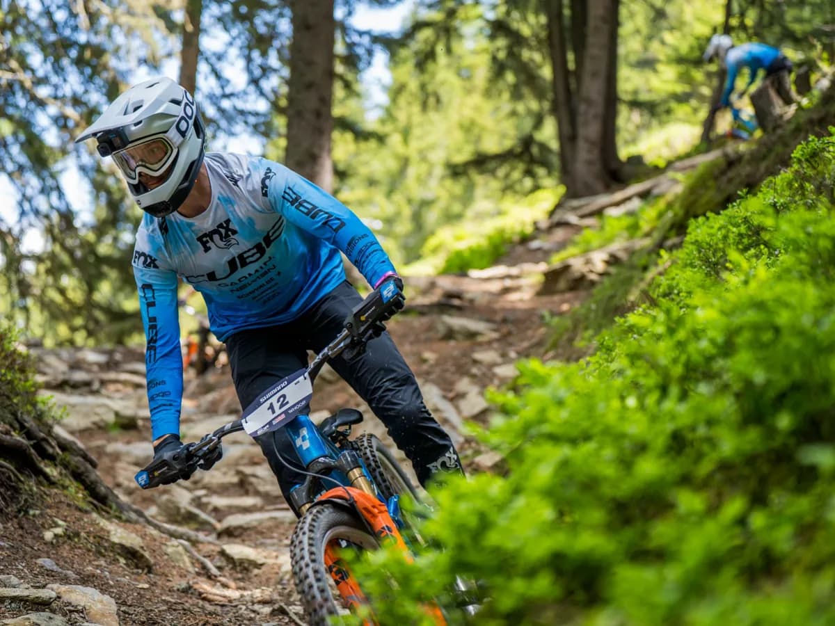 Mountainbiker im Renneinsatz auf einer Downhill-Strecke.