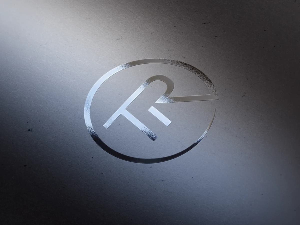 Geprägtes Logo von Robert Treitinger auf dunklem Papier.